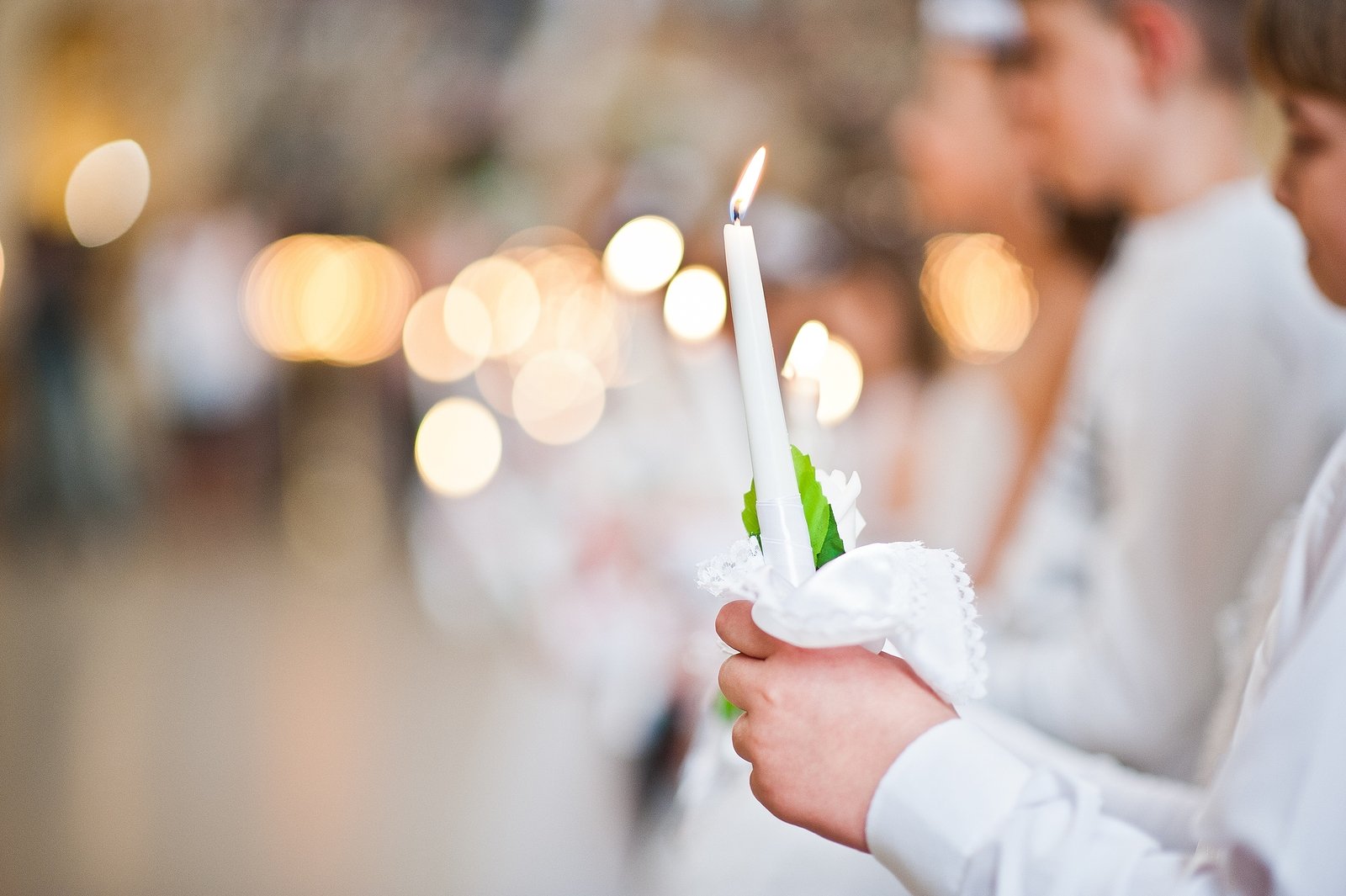 Close-up of a candle and flame in hand of altar boy