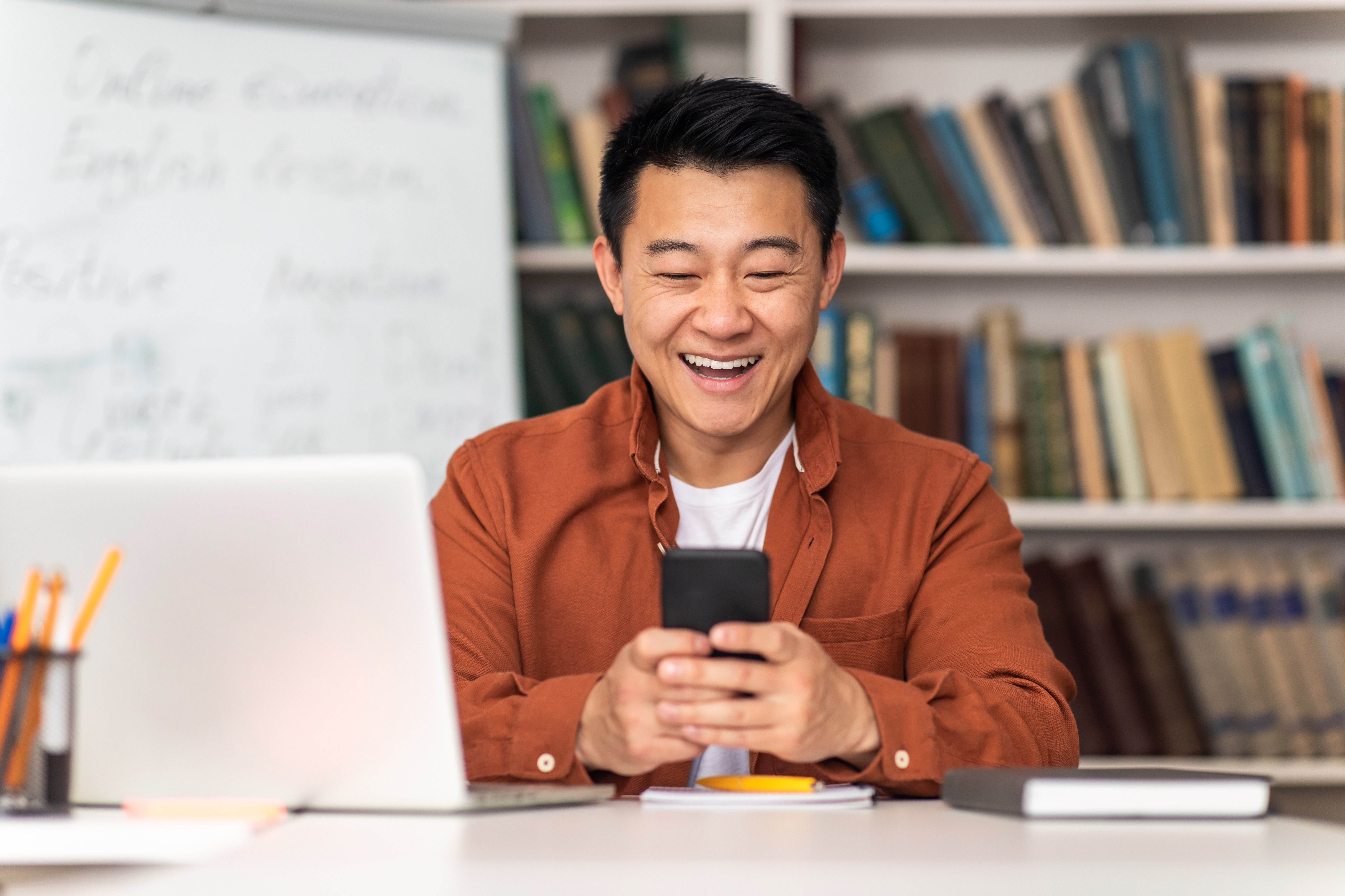 Smiling Asian Teacher Using a Phone App