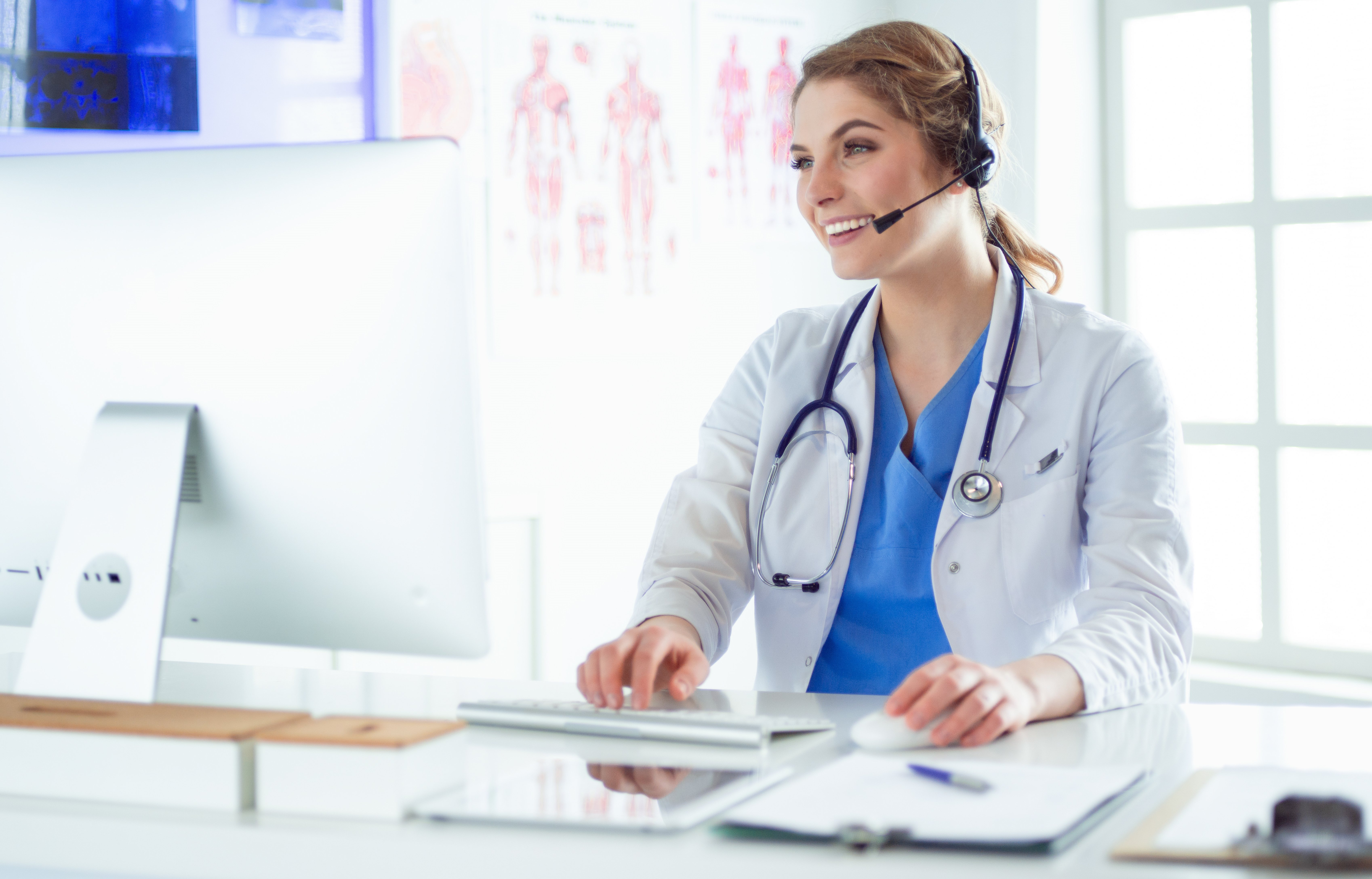 Young female doctor wearing a headset speaking on a video call